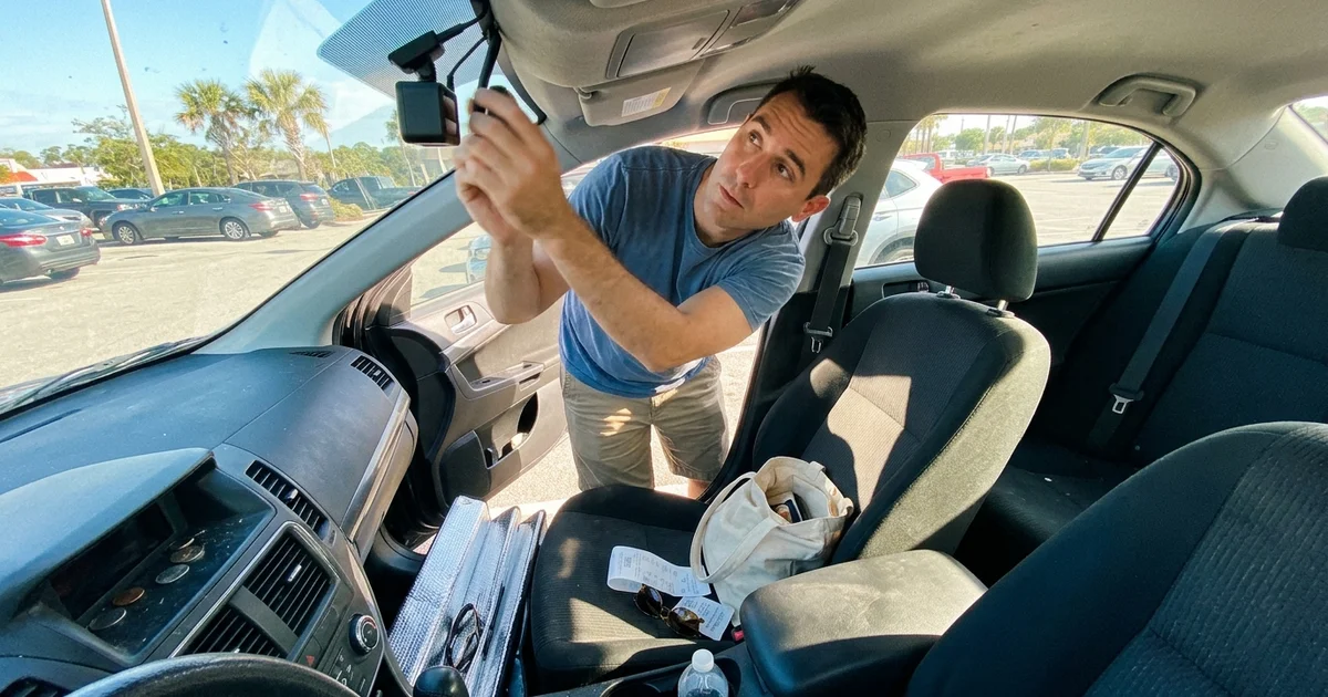 Driver checking the top of their windshield for a forward-facing camera module
